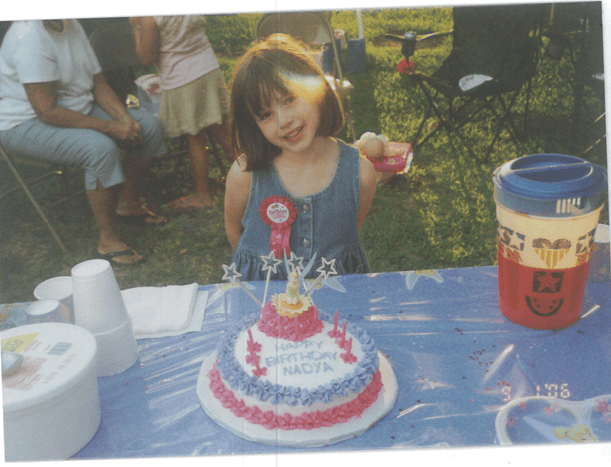 Brown headed girl in front of Tinkerbell birthday cake