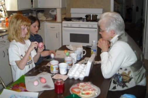 two small girls Dying Easter Eggs with grandmother